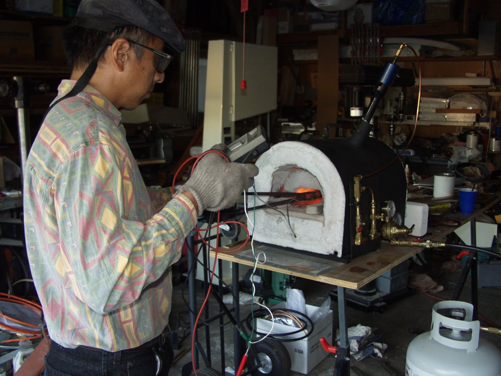 Eric Cheng helps me test the temp to see how low we can get he forge, to forge some brass. We used a ceramic probe that Eric built attached to a volt meter and measured the milliamps to determine that.